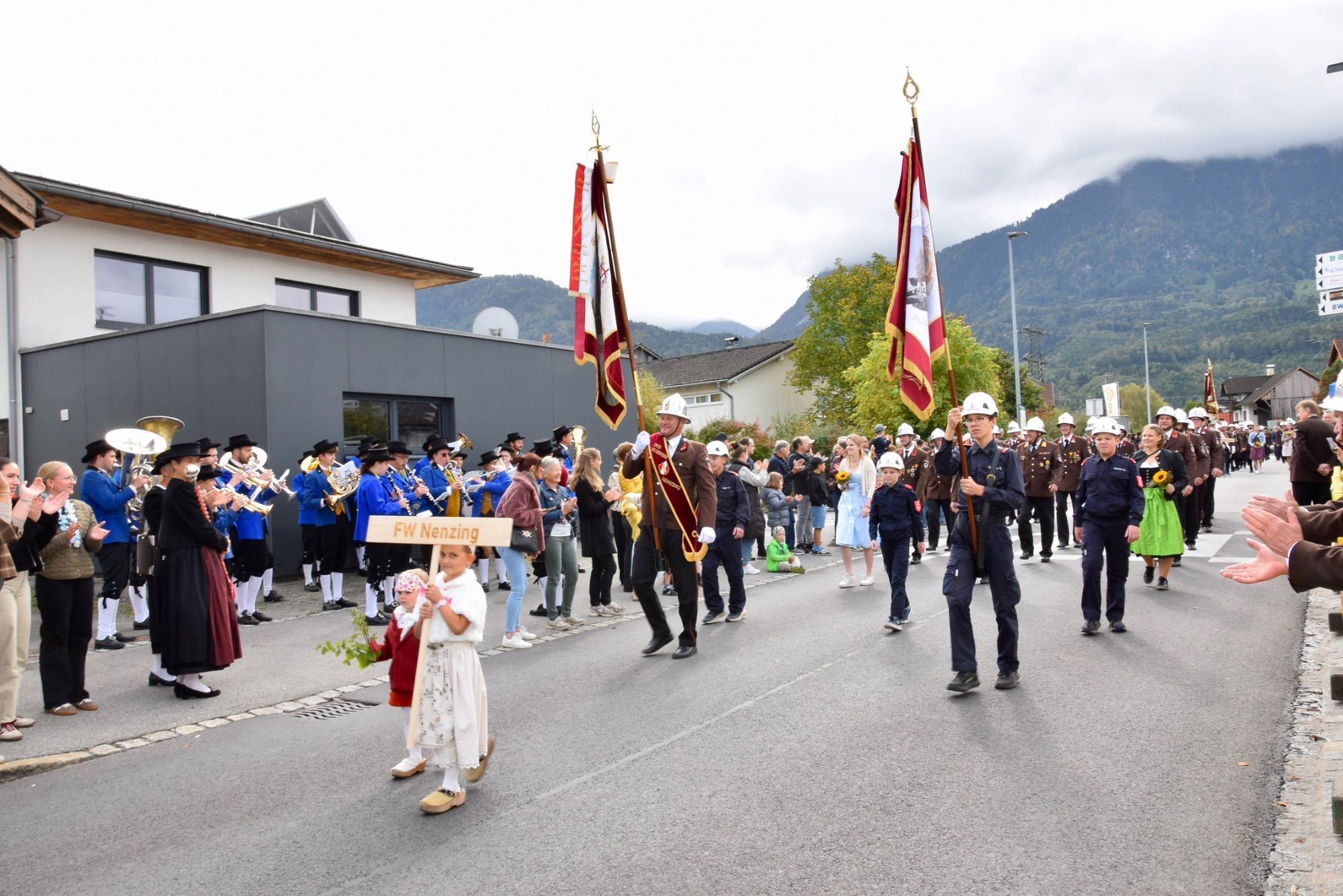 Festumzug mit verschiedenen Walgauer Musikvereinen und Walgauer Feuerwehren in der Bahnhofstraße Schlins. Anschließend musizierte die Gemeinde Musik Schlins neben den Fahnen der Musikkapellen und Feuerwehren im Festzelt beim Feuerwehrgerätehaus Schlins.