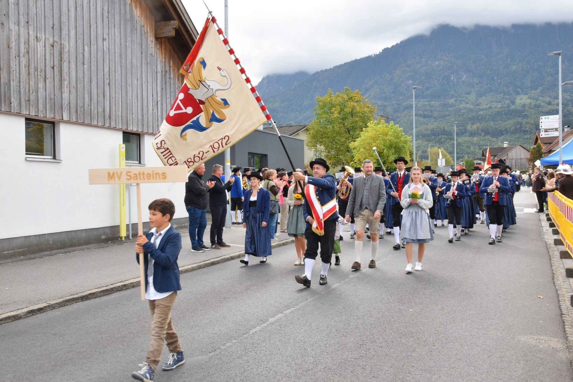 Festumzug mit verschiedenen Walgauer Musikvereinen und Walgauer Feuerwehren in der Bahnhofstraße Schlins. Anschließend musizierte die Gemeinde Musik Schlins neben den Fahnen der Musikkapellen und Feuerwehren im Festzelt beim Feuerwehrgerätehaus Schlins.
