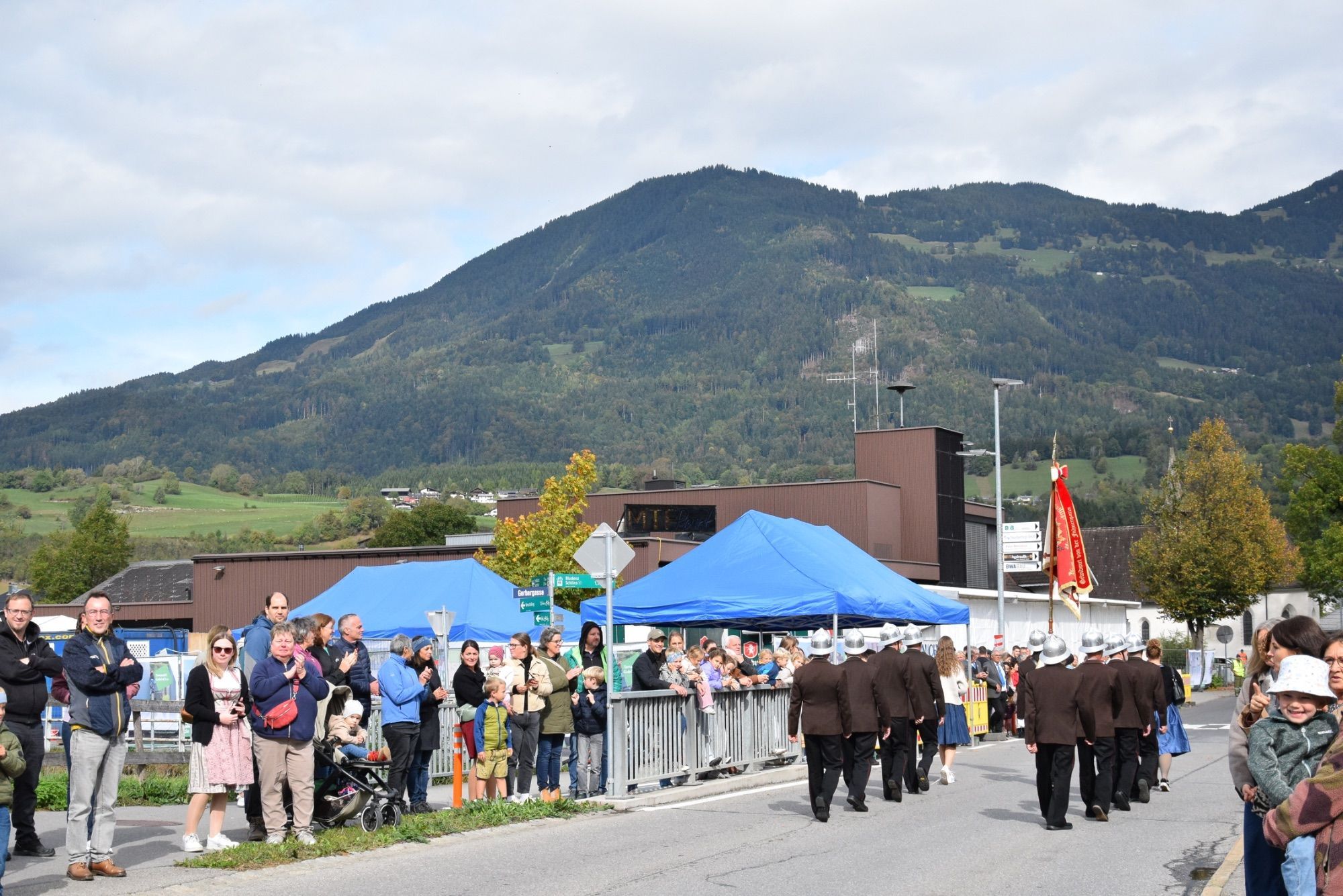 Festumzug mit verschiedenen Walgauer Musikvereinen und Walgauer Feuerwehren in der Bahnhofstraße Schlins. Anschließend musizierte die Gemeinde Musik Schlins neben den Fahnen der Musikkapellen und Feuerwehren im Festzelt beim Feuerwehrgerätehaus Schlins.