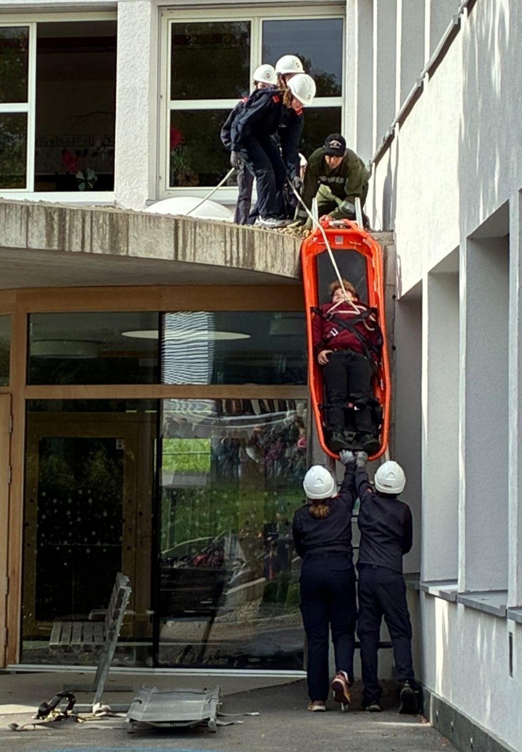Mit Leiter und Schleifkorbtrage wurden verletzte Personen vom Schuldach gerettet.