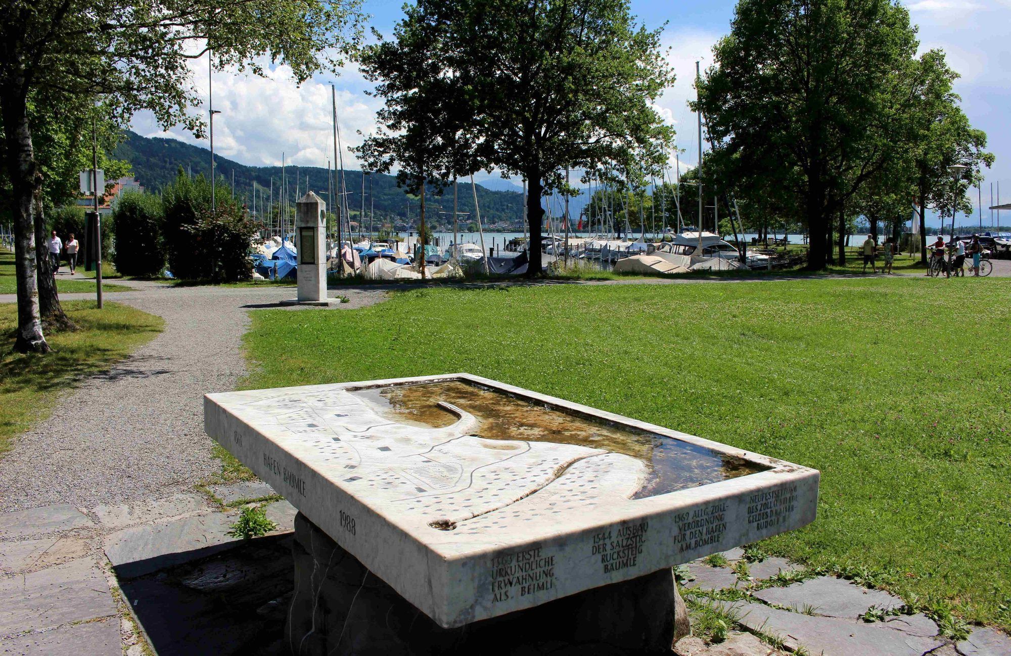 Reliefbrunnen mit Hinweisen auf eine jahrhundertelange Hafengeschichte am Bäumle. Im Hintergrund der Wetterobelisk.