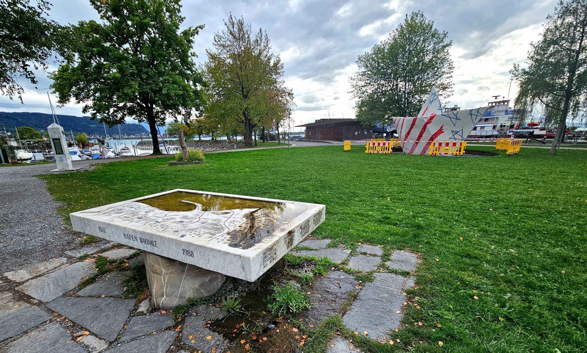 Das „Papierboot“ aus der Madame Butterfly-Kulisse der Bregenzer Festspiele hat am Hafen in Lochau im Ensemble Reliefbrunnen, Wetterobelisk, Artenvielfalt-Kompass und Alte Fähre nun seinen endgültigen Liegeplatz gefunden.