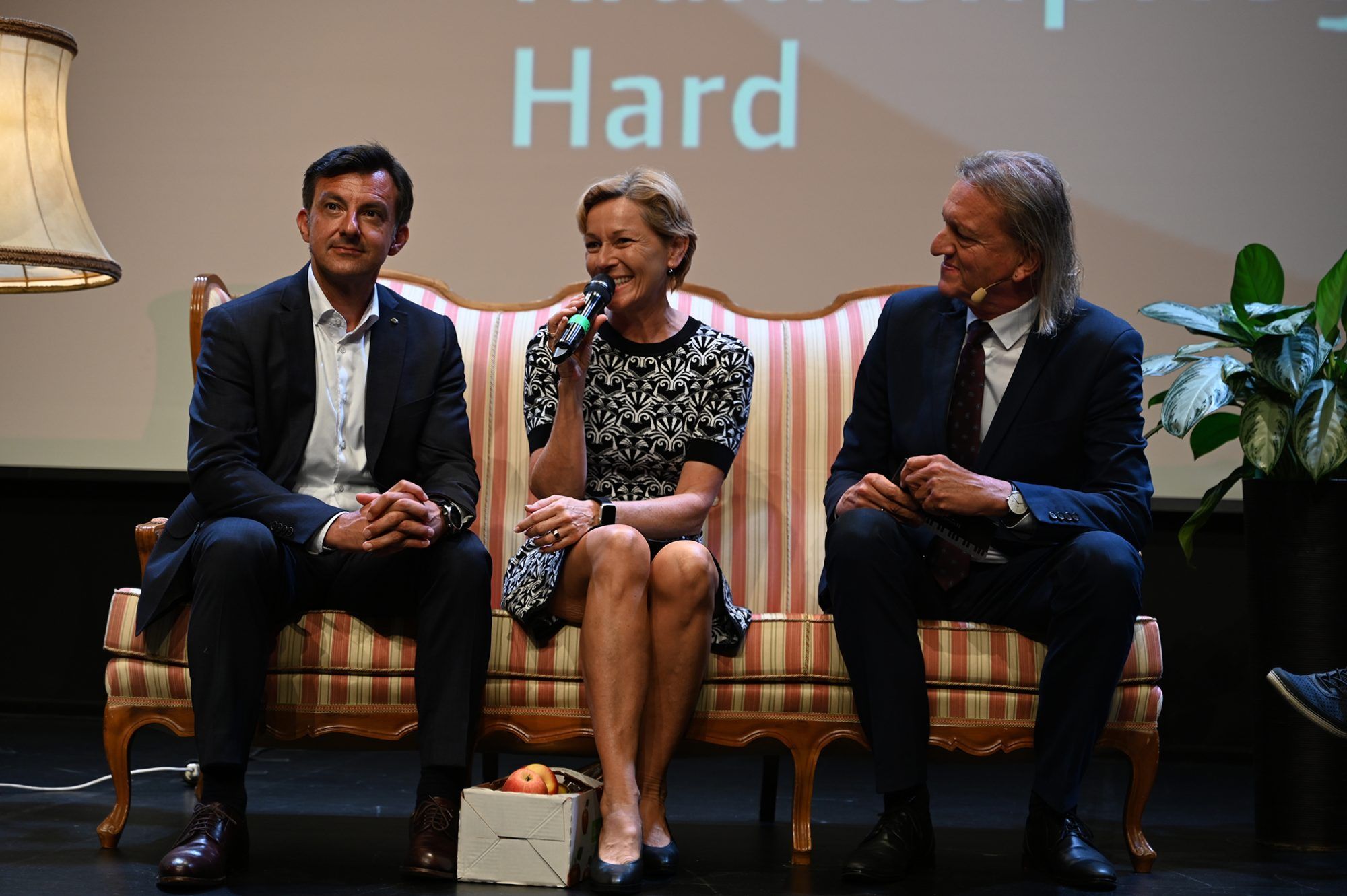 Bgm. Staudinger und Markus Linder lauschten, als LR Martina Rüscher gratulierte und gesunde Äpfel als Geschenk überbrachte.