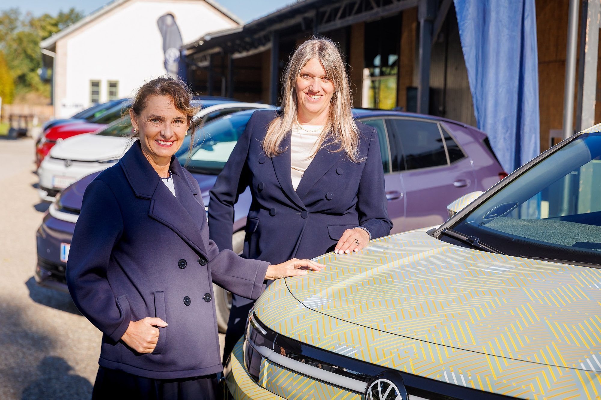 Stolz auf das Line-Up: VW Markenleiterin Gudrun Zeilinger (re.) und Pressesprecherin Karin Angerer (li.) vor der Reige an elektrischen Modellen ihrer Marke im burgenländischen Donnerskirchen
