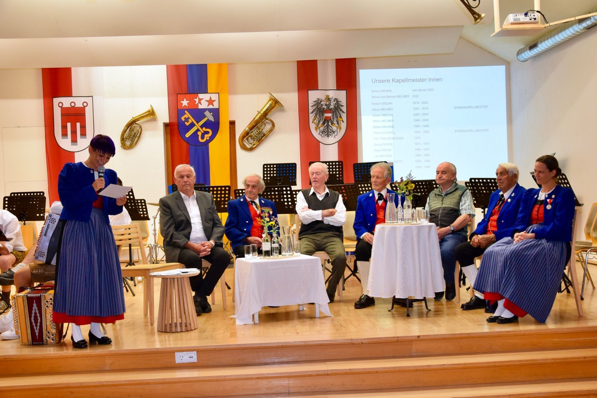 Obfrau Kathi Gabl, Bgm. a. D. Willi Säly, Lorenz Vallaster, Martin Vallaster, Franz Fleisch, Josef Bargehr, Adolf Loretz und Obfrau Katharina Erhard. Auf der Bühne fanden die Interviews mit dem ehemaligen Bürgermeister und den langjährigen Musikvereinsmitgliedern statt.