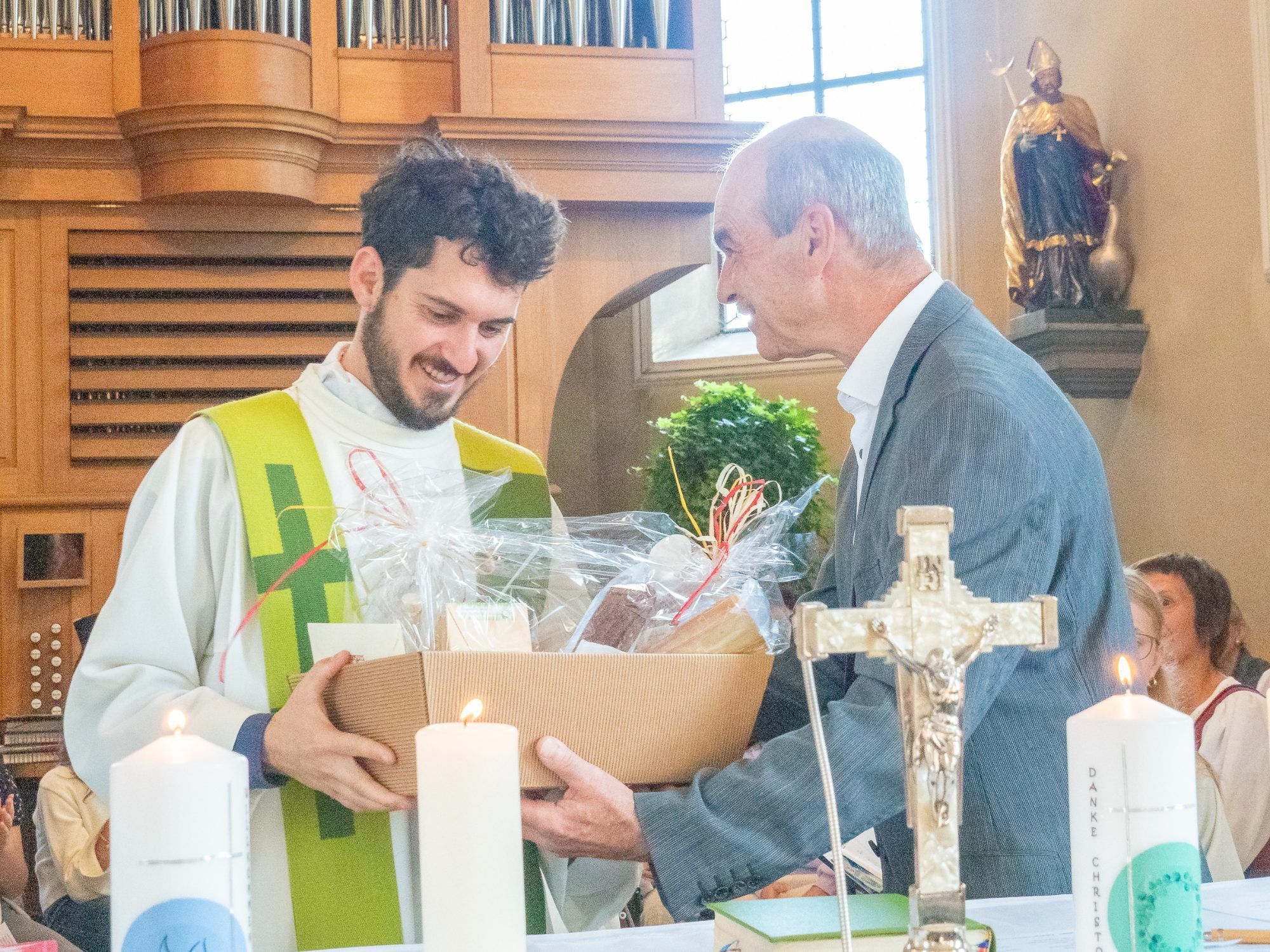 Kirchenrat Albert Rinderer überreicht dem neuen Pfarrer das Willkommensgeschenk