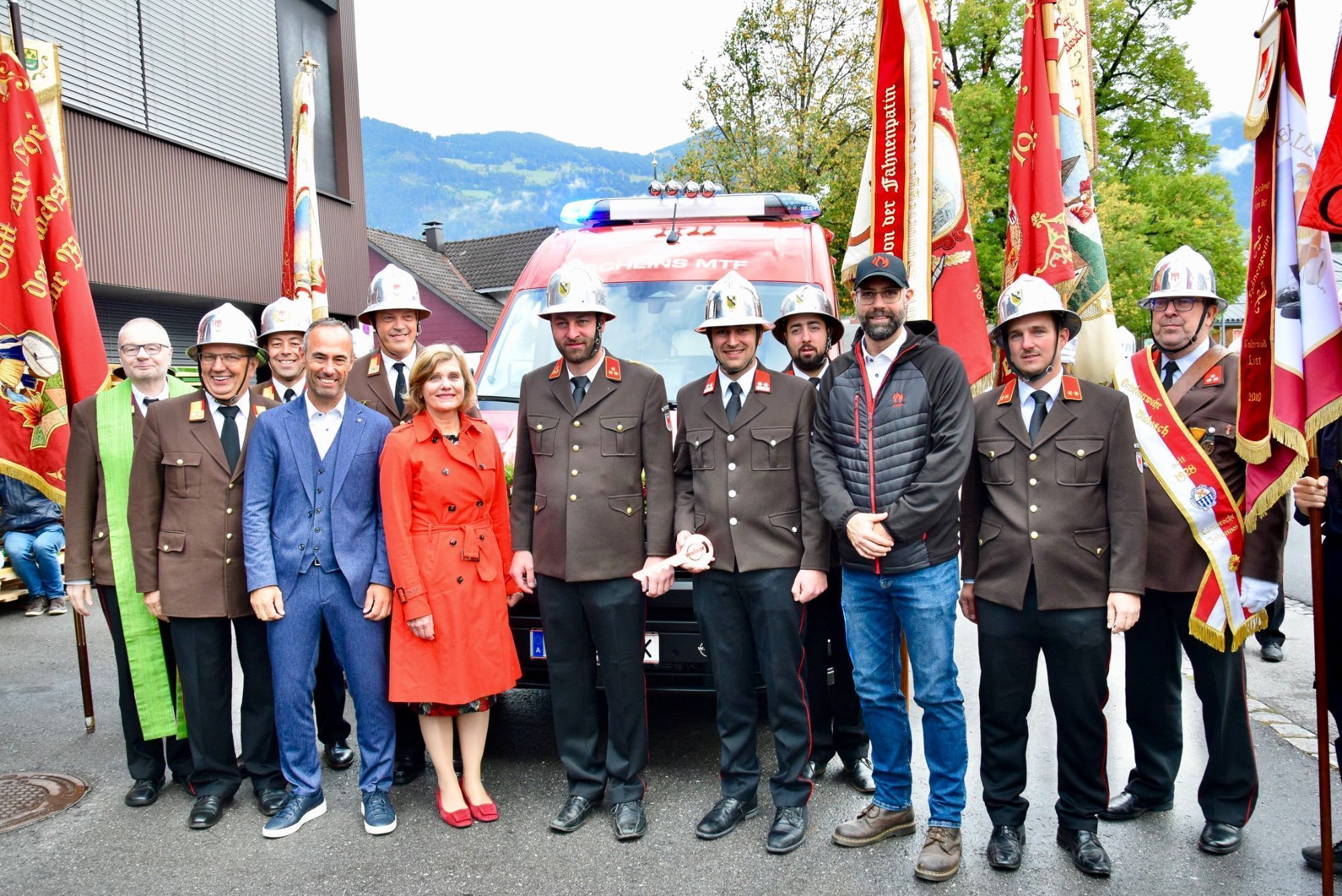 Ein Freudentag für ganz Schlins: Landesrätin Barbara Schöbi-Fink, Bürgermeister Wolfgang Lässer (links von ihr), Feuerwehrvertreter, Feuerwehrfähnriche und Daniel Scheibenstock, Firma Walser (3. v. r.)