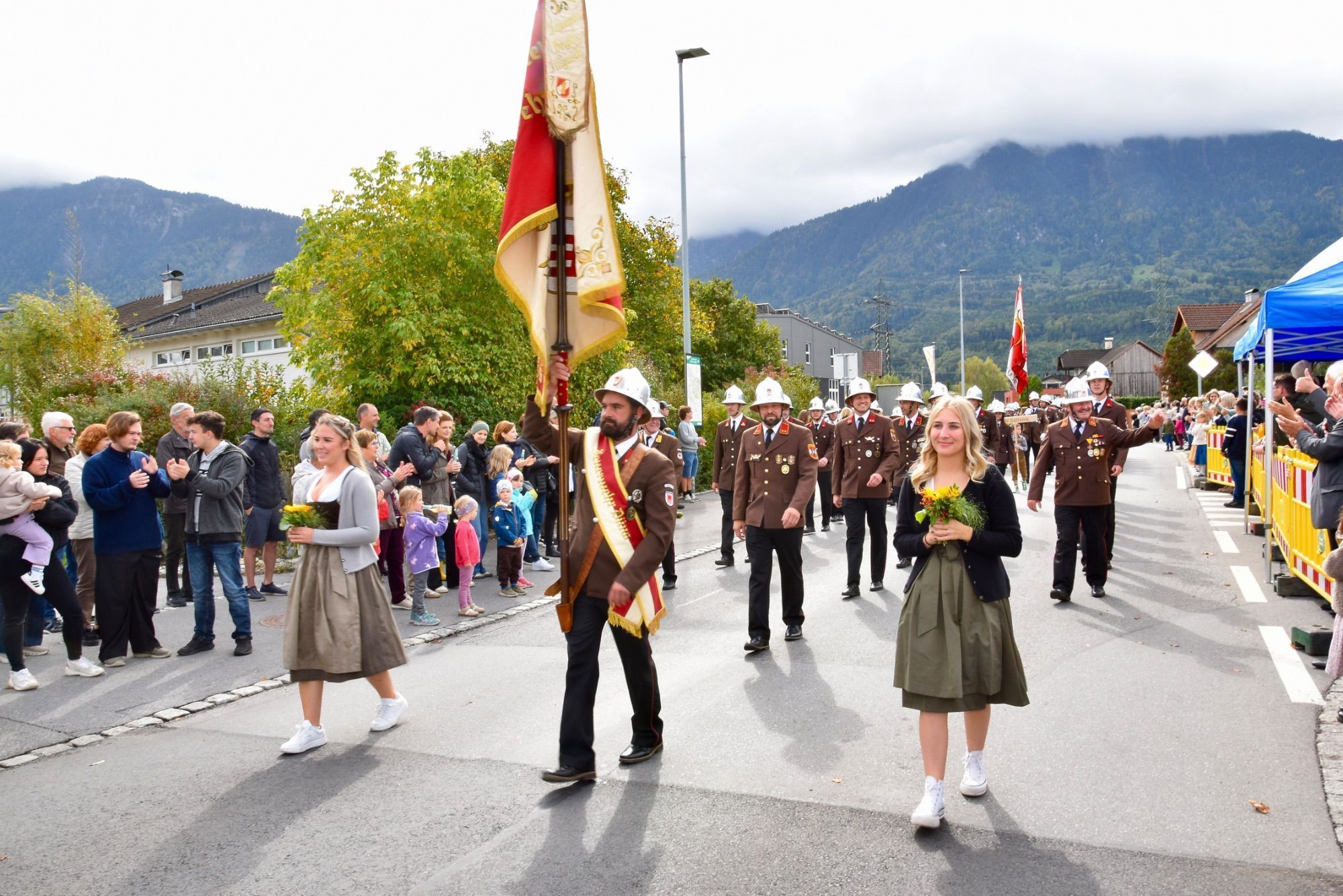 Festumzug mit verschiedenen Walgauer Musikvereinen und Walgauer Feuerwehren in der Bahnhofstraße Schlins. Anschließend musizierte die Gemeinde Musik Schlins neben den Fahnen der Musikkapellen und Feuerwehren im Festzelt beim Feuerwehrgerätehaus Schlins.