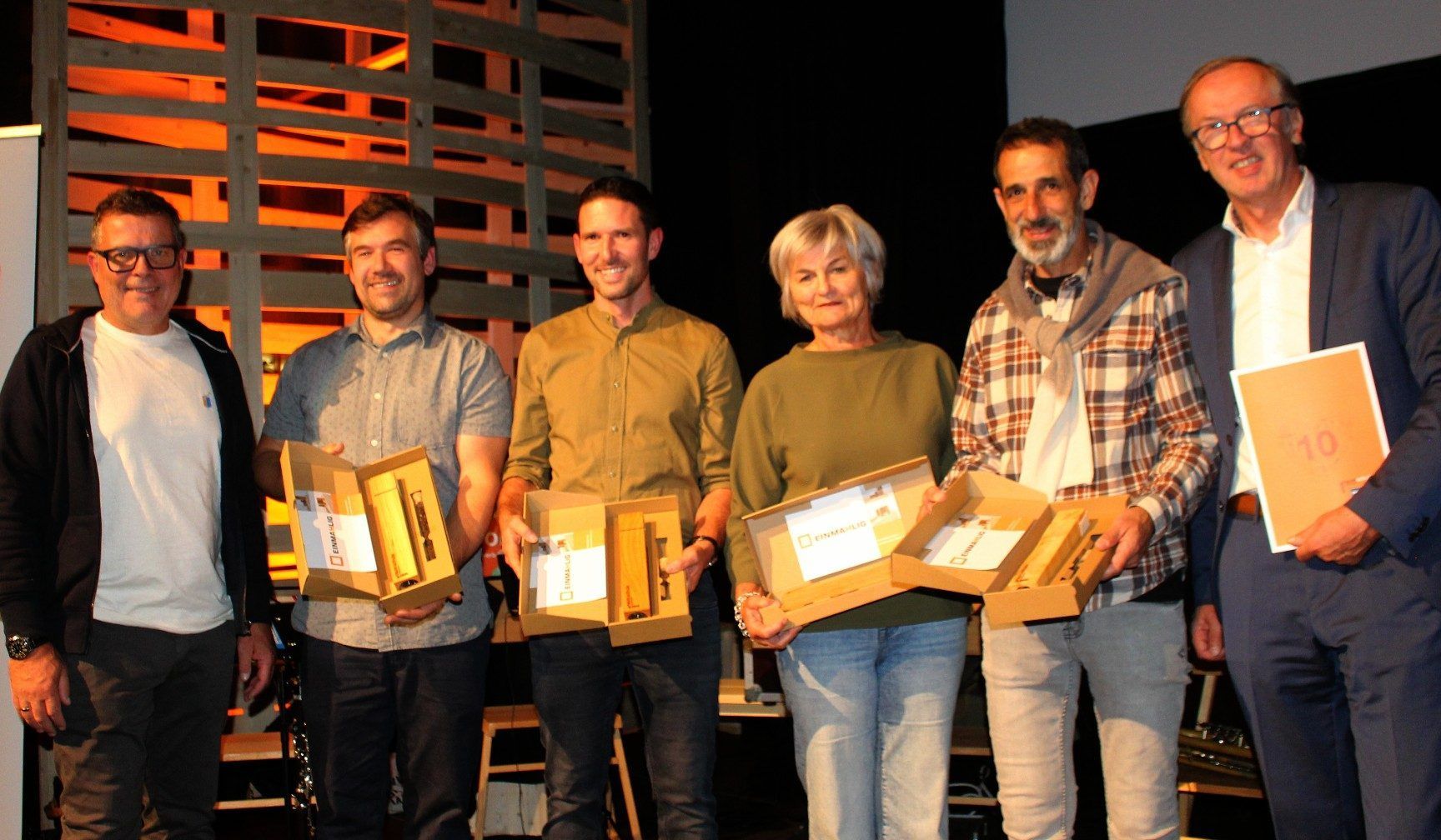 Von Fredy Kloser (Werkraum-Vorstandsmitglied, li.) und Dir. Mario Hammerer (re.) gab es für Martin Greussing, Tobias Sutterlüty, Petra Raid und Gerhard Berlinger als Dankeschön ein symbolträchtiges Geschenk: Pfeffermühlen „einma(h)lig“.