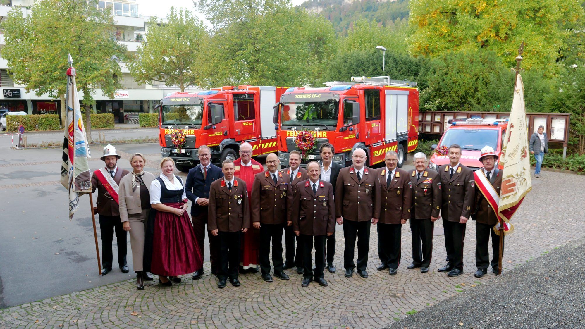 Die Ehrengäste aus Stadt und Land vor den drei neuen Einsatzfahrzeugen der Feuerwehr Tosters, die künftig die Schlagkraft bei Gefahrguteinsätzen stärken.