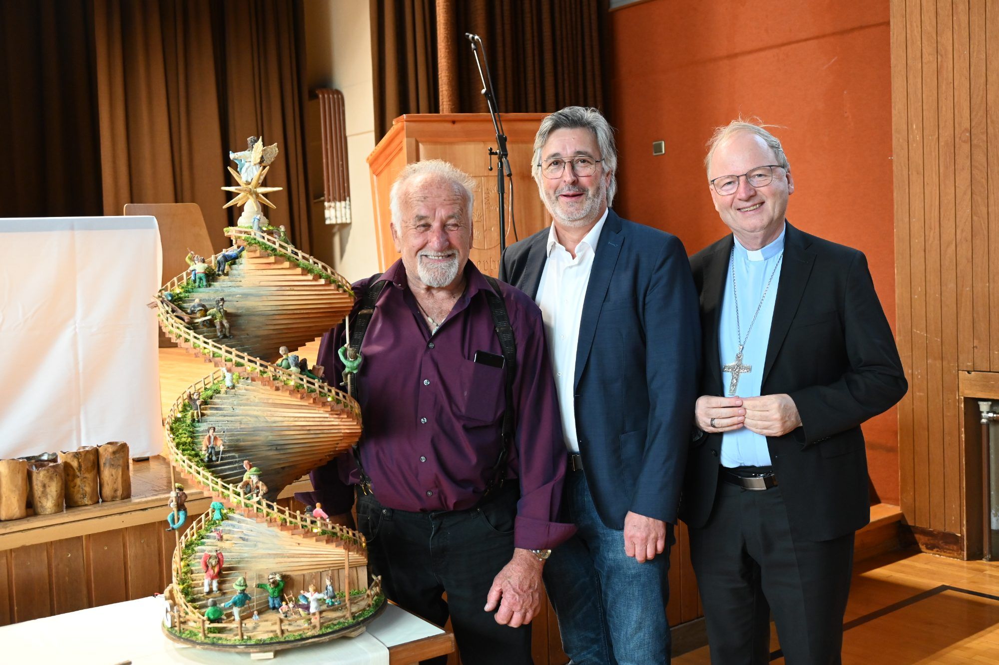 Künstler Otmar Ganahl, Oswald Wachter und Bischof Benno Elbs mit dem besonderen Lebensweg, gestaltet von Otmar Ganahl.