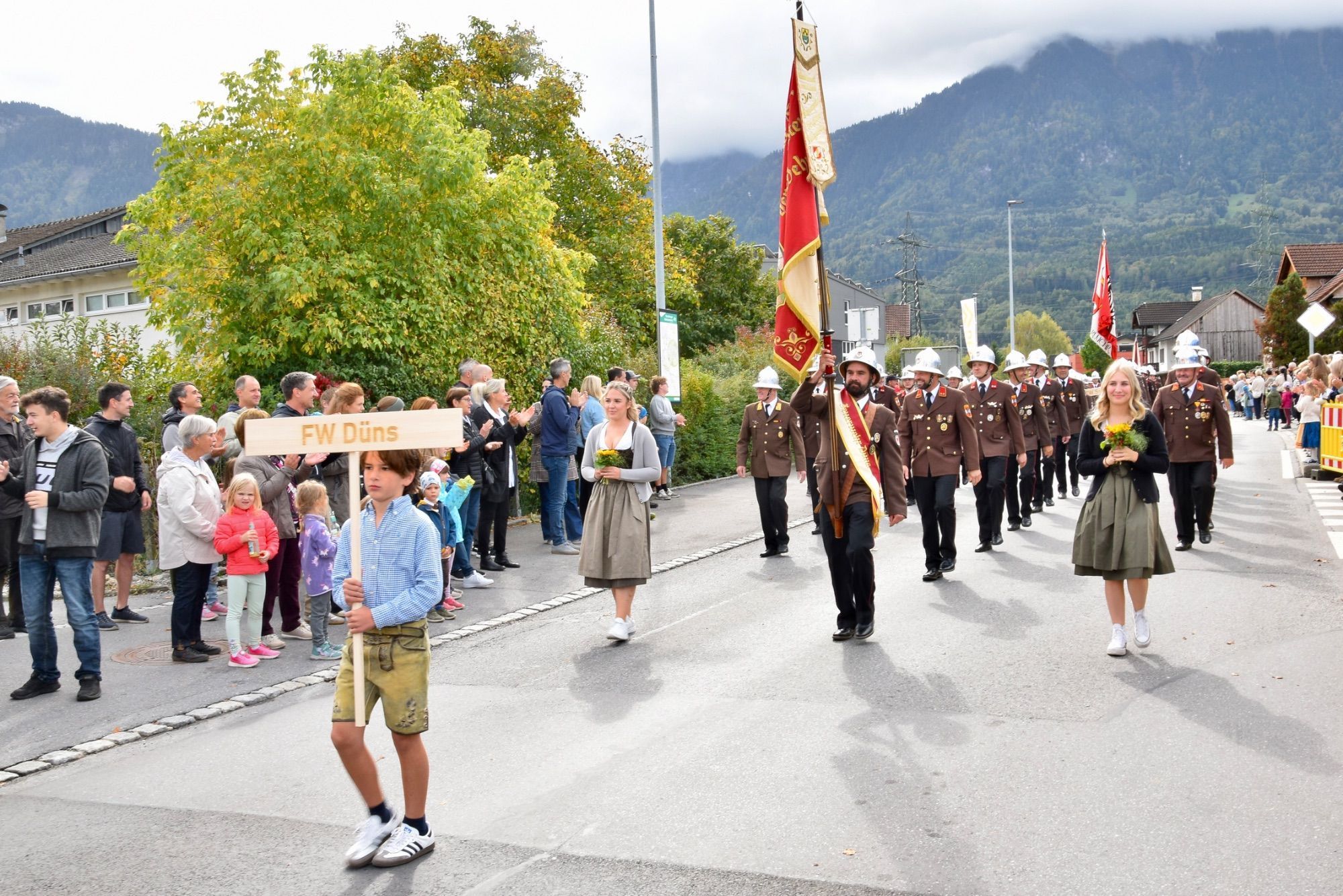 Festumzug mit verschiedenen Walgauer Musikvereinen und Walgauer Feuerwehren in der Bahnhofstraße Schlins. Anschließend musizierte die Gemeinde Musik Schlins neben den Fahnen der Musikkapellen und Feuerwehren im Festzelt beim Feuerwehrgerätehaus Schlins.